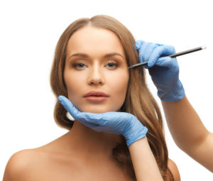 beautician marking womans face for botox injections