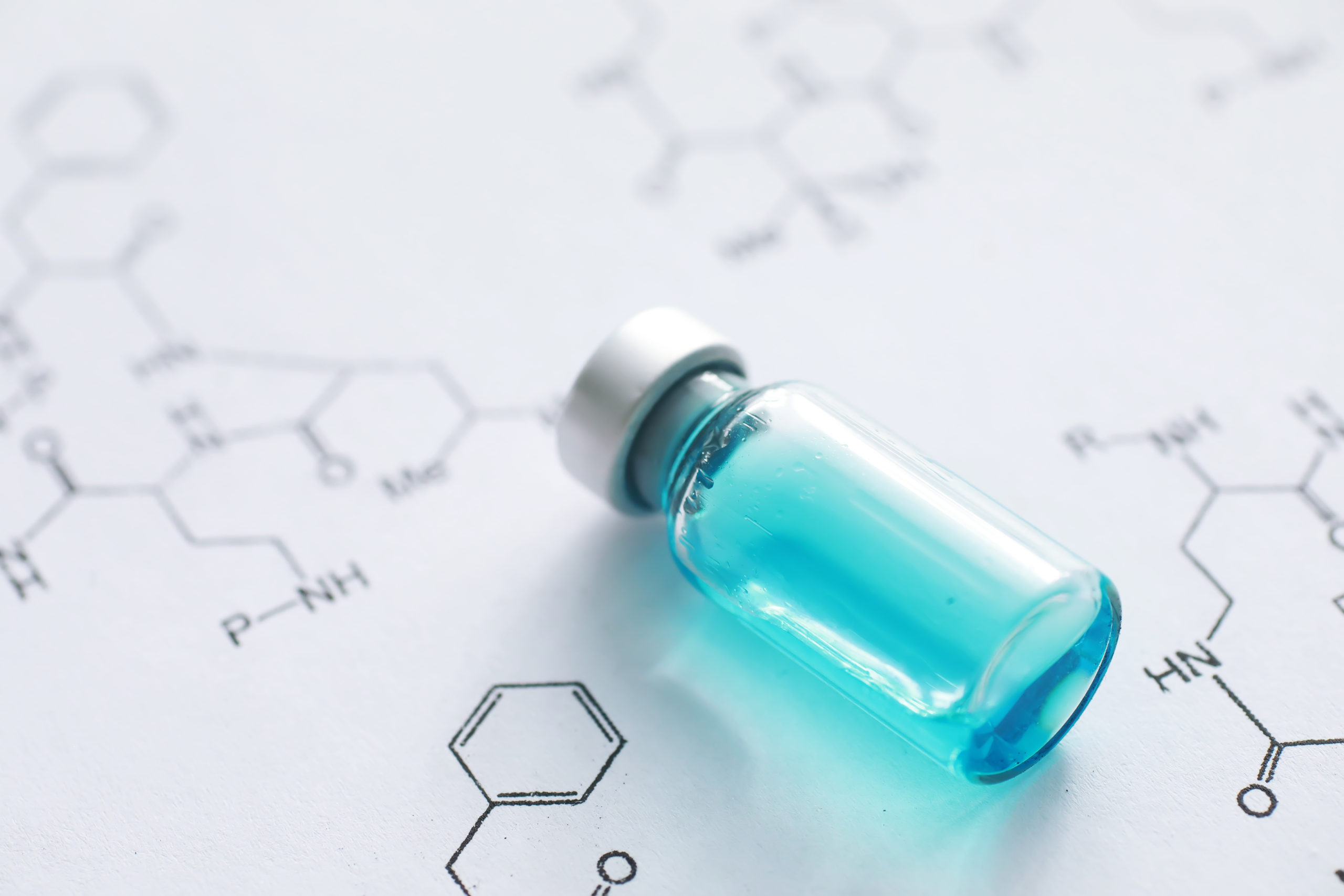 small jars with injection and syringe for injection on a blue ba