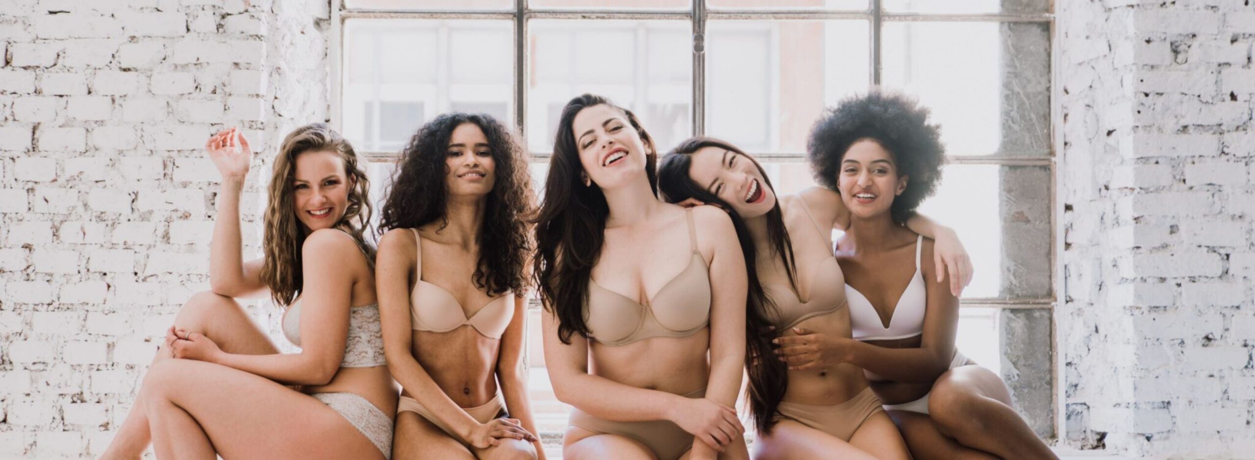 a group of women of different ethnicities posing in their underwear