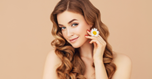 model with red hair holding a daisy